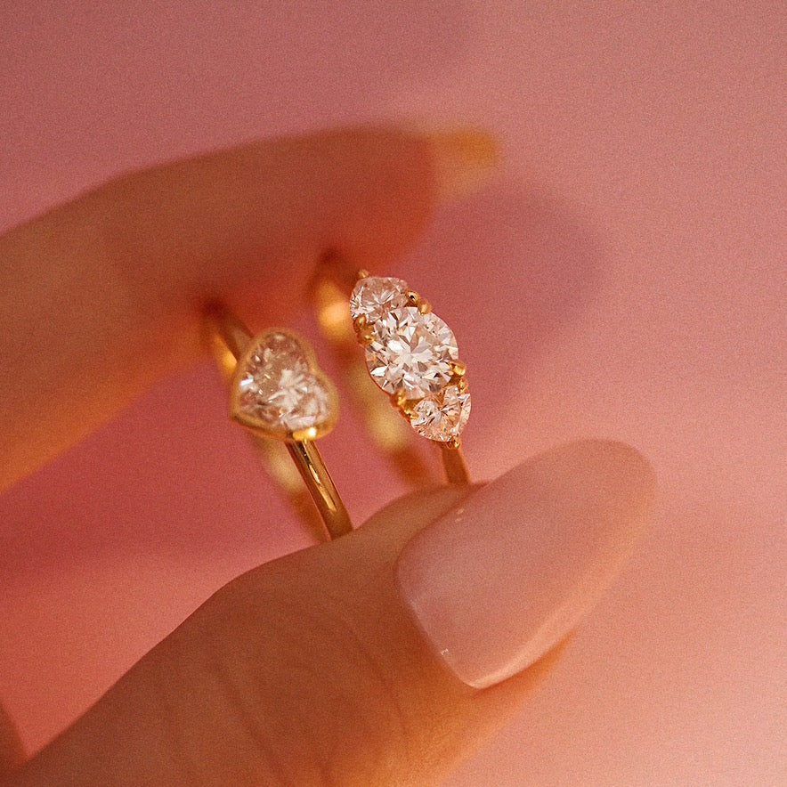 18ct gold ‘Hidden Hearts’ ring with a 0.90ct round shaped diamond centre stone and two heart shaped diamonds