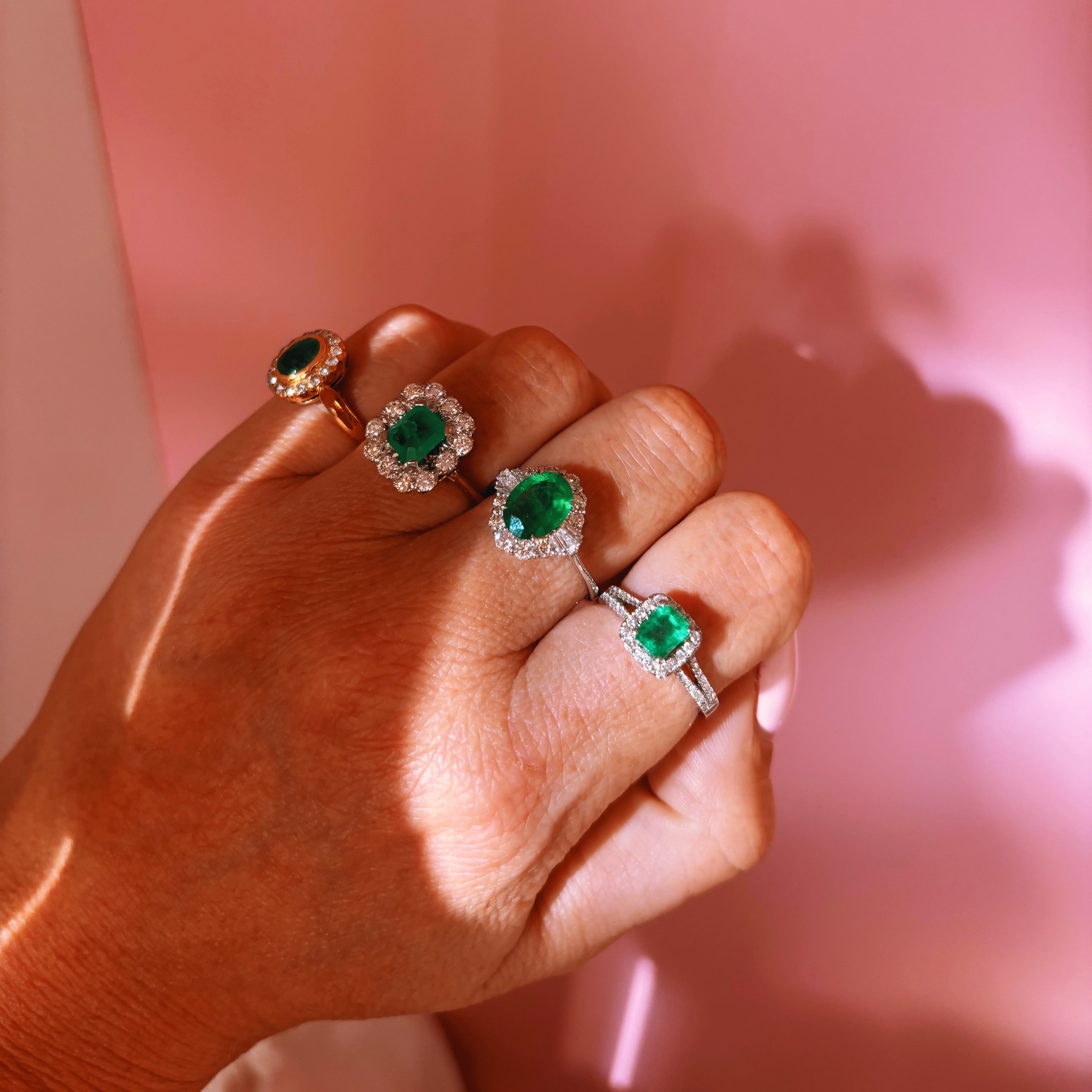 18ct gold bezel set, oval emerald and diamond cluster ring