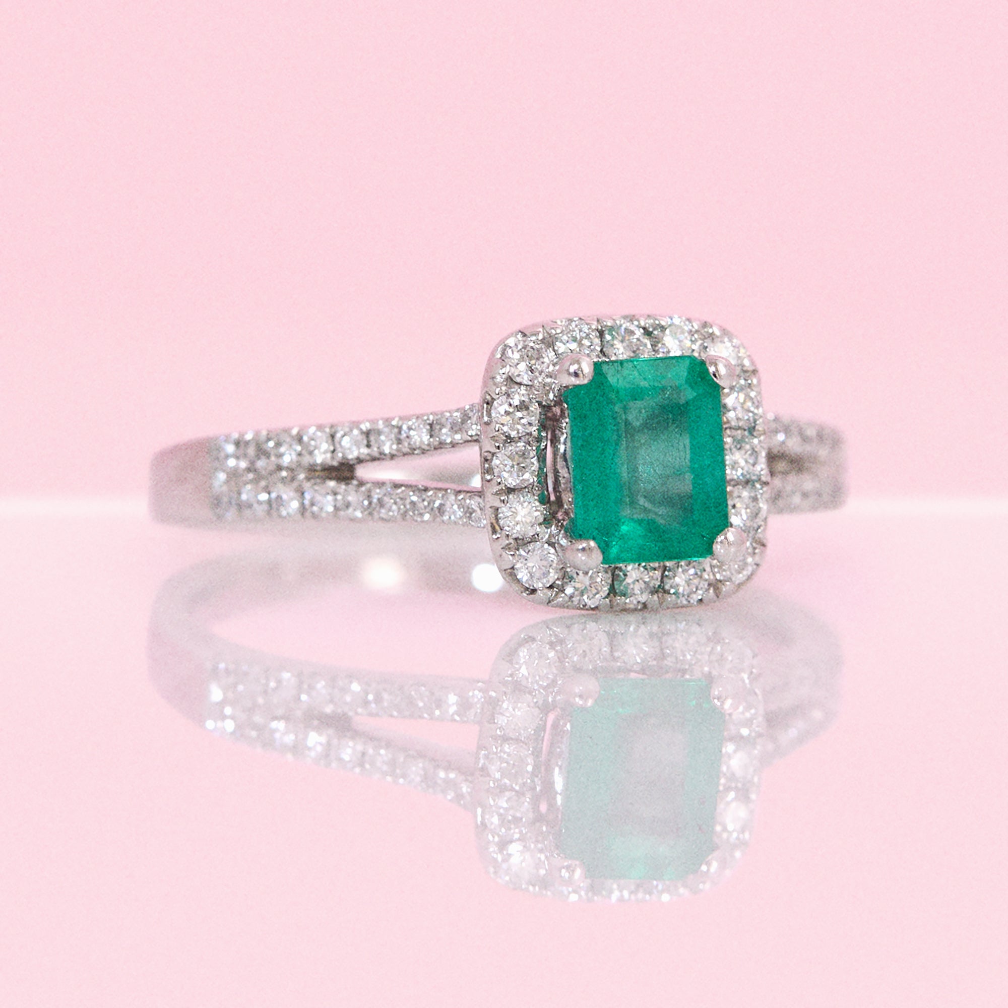 Platinum emerald cut emerald and diamond split shoulder ring