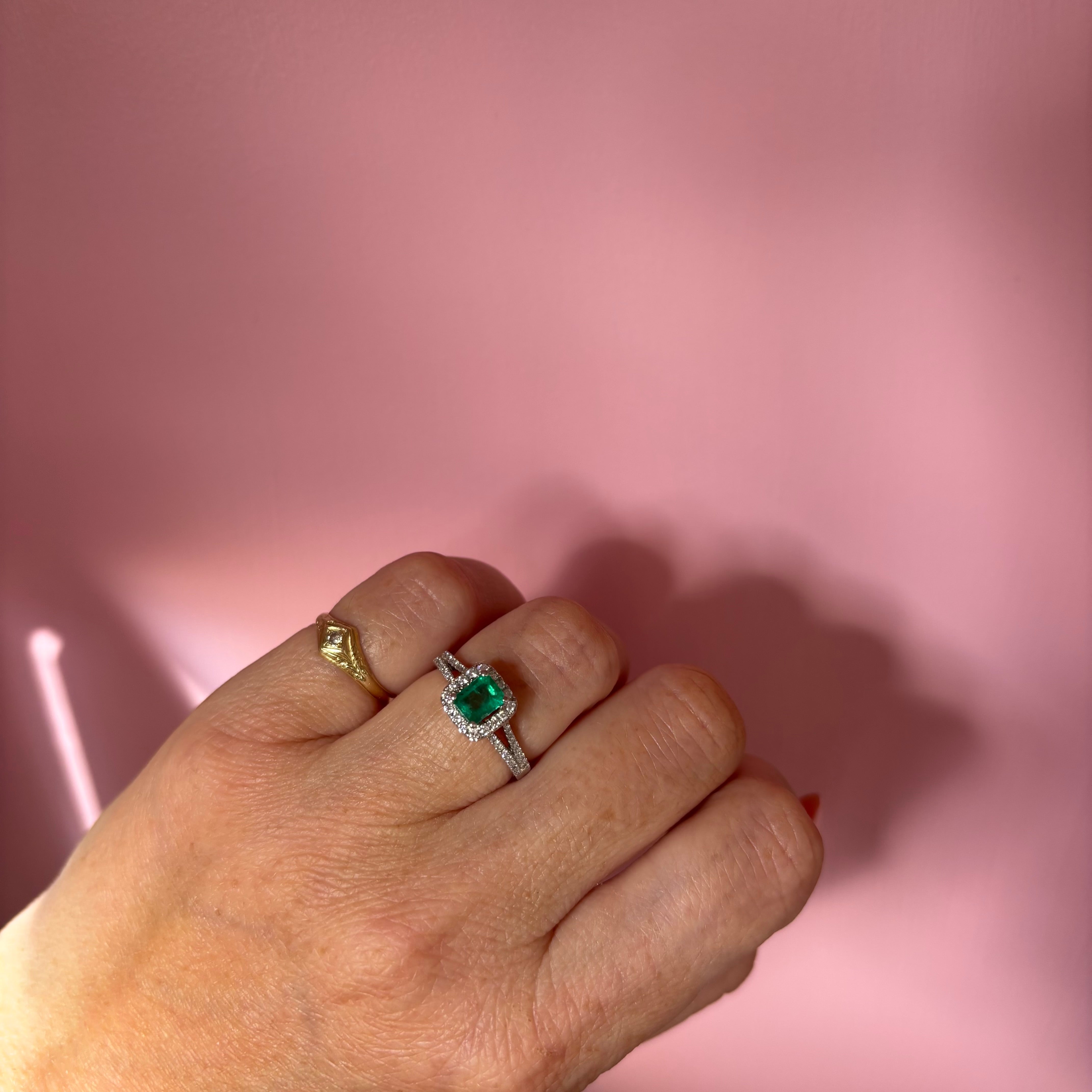 Platinum emerald cut emerald and diamond split shoulder ring