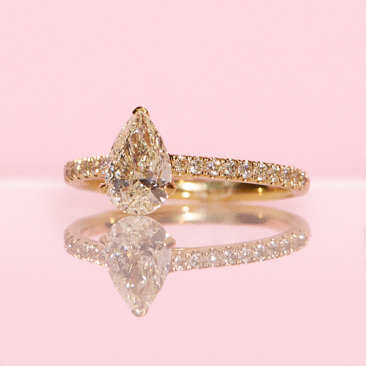 18ct yellow gold 1.0ct pear shaped diamond ring on a diamond half eternity band