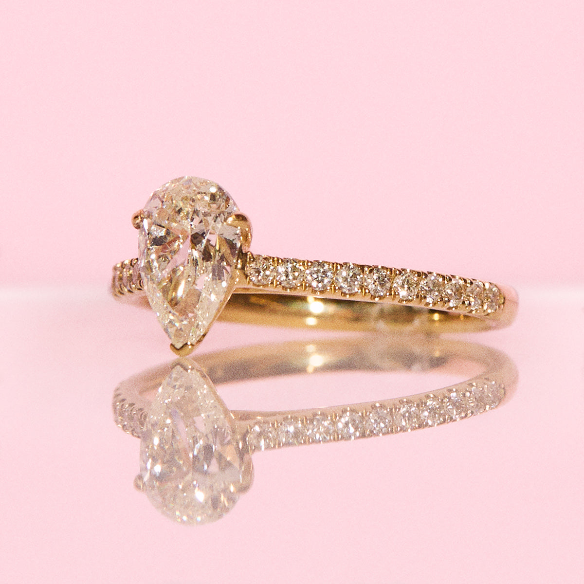 18ct yellow gold 1.0ct pear shaped diamond ring on a diamond half eternity band