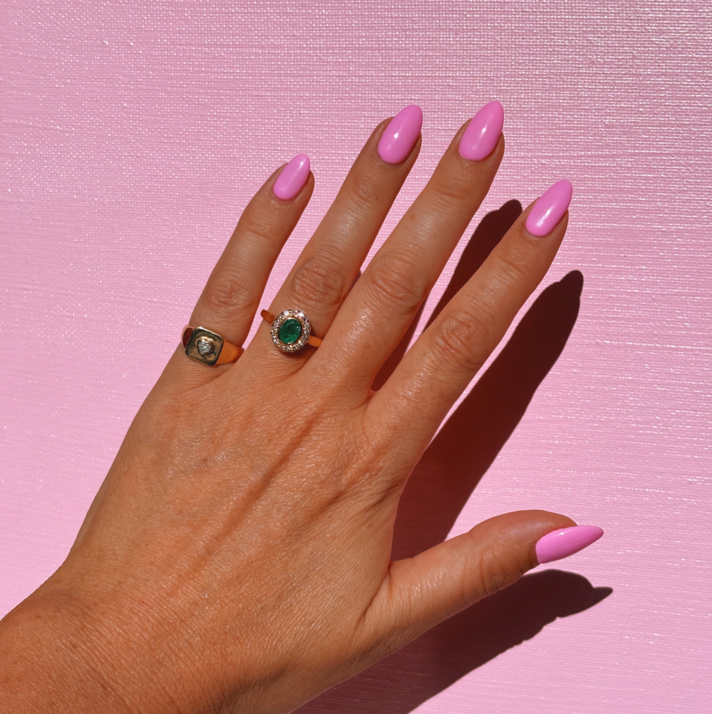 18ct gold bezel set, oval emerald and diamond cluster ring