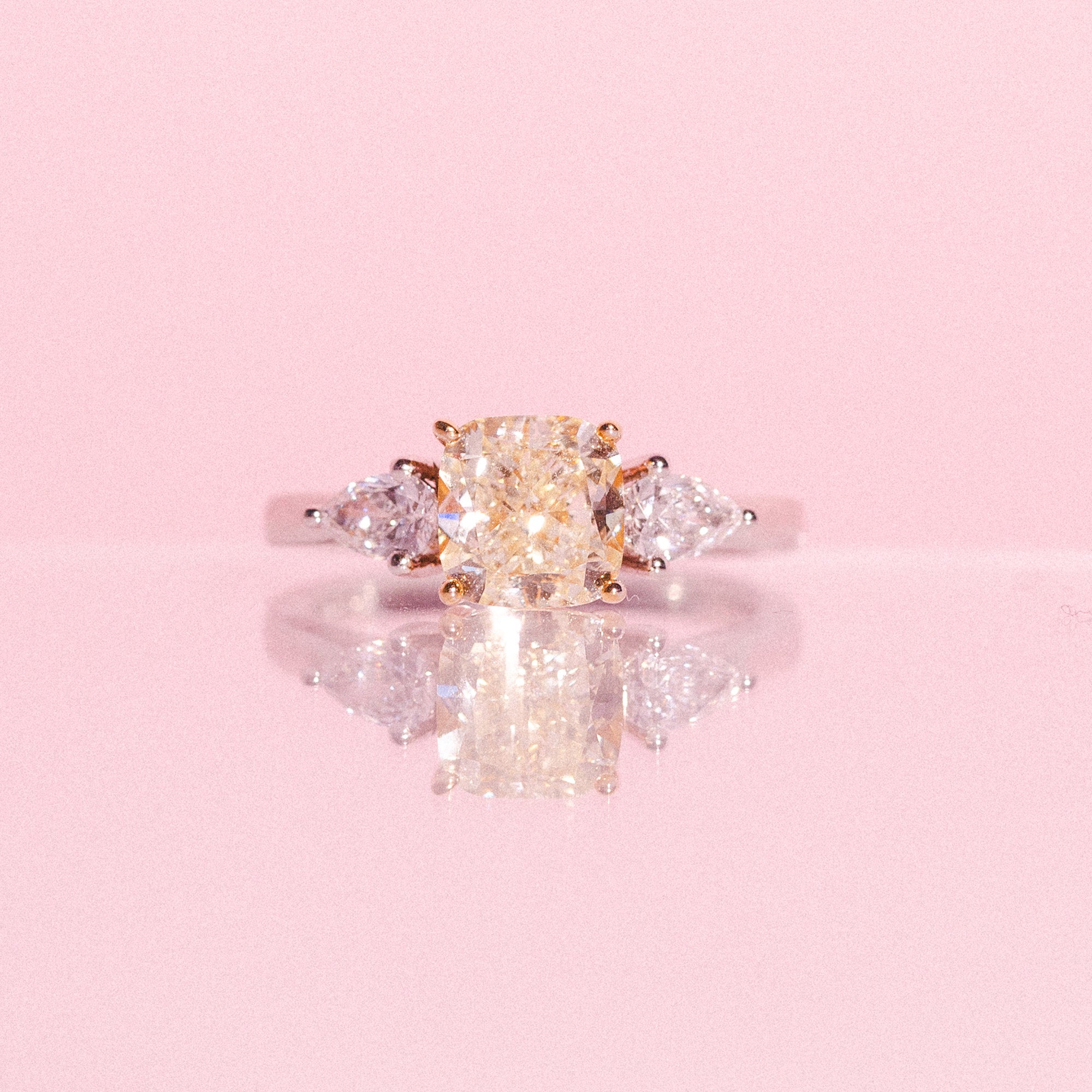 Platinum ring set with one cushion cut yellow diamond and two pear shaped diamonds