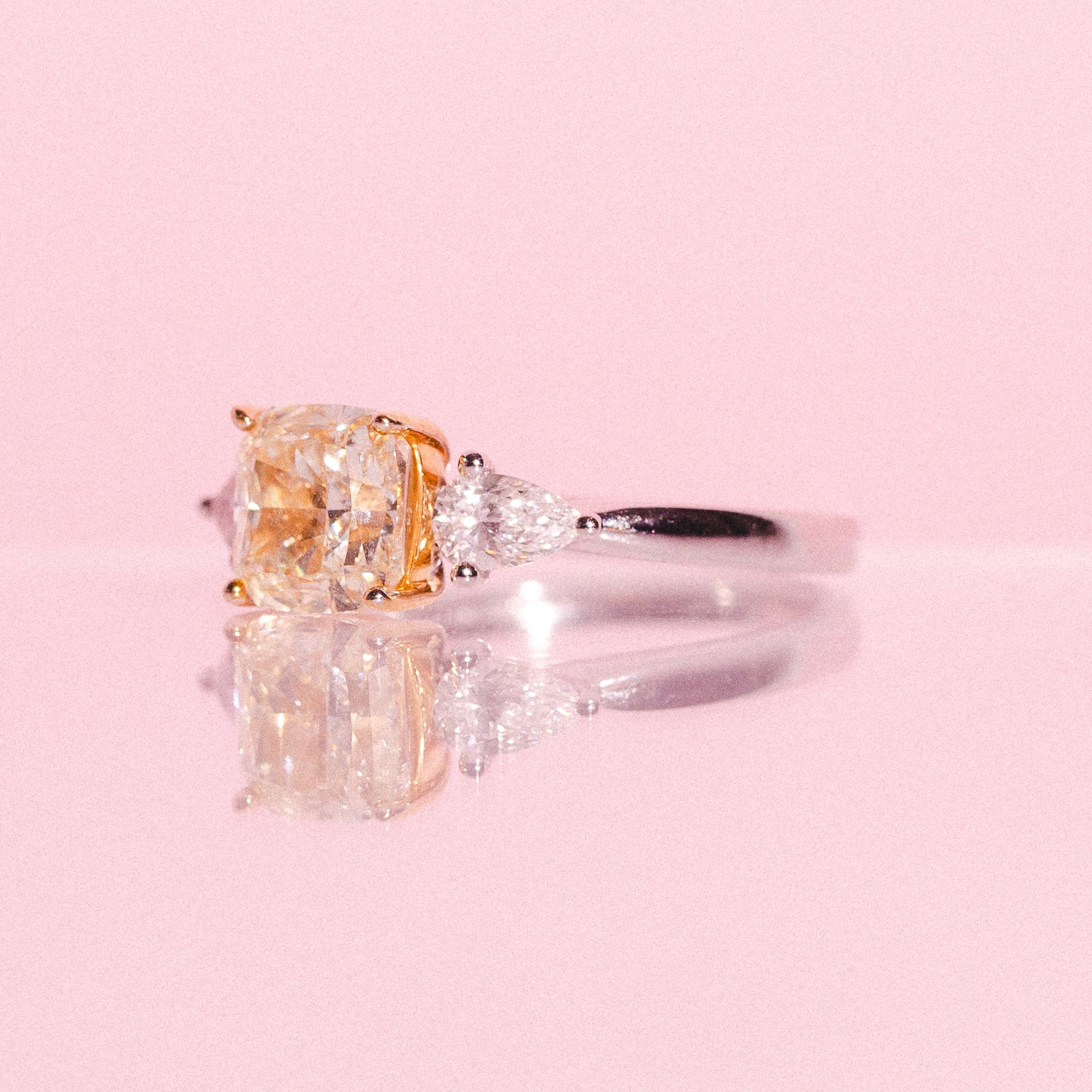 Platinum ring set with one cushion cut yellow diamond and two pear shaped diamonds