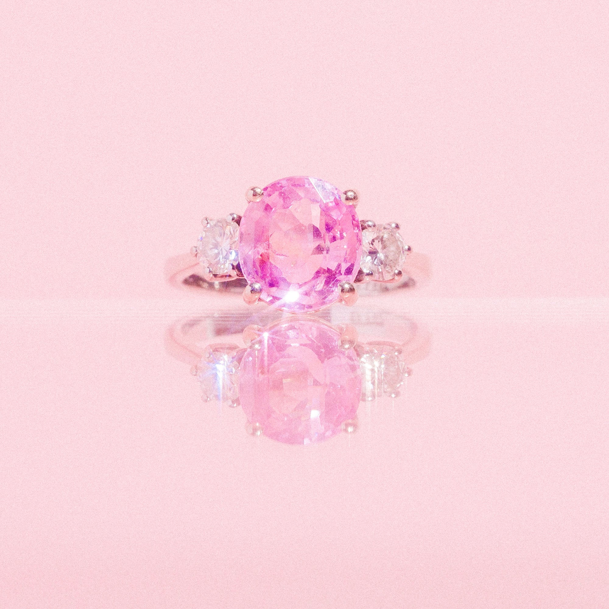 18ct white gold ring set with a pink sapphire and two diamonds