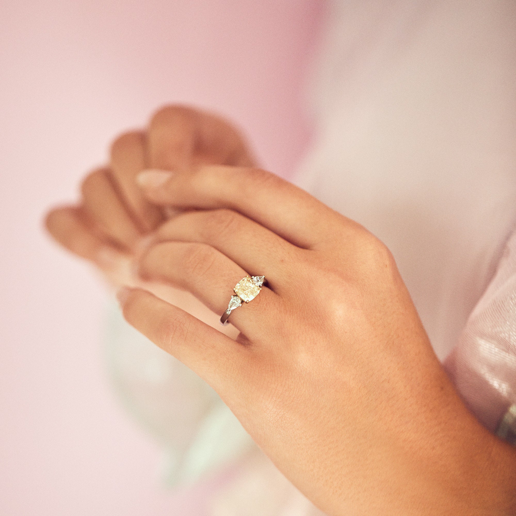 Platinum ring set with one cushion cut yellow diamond and two pear shaped diamonds