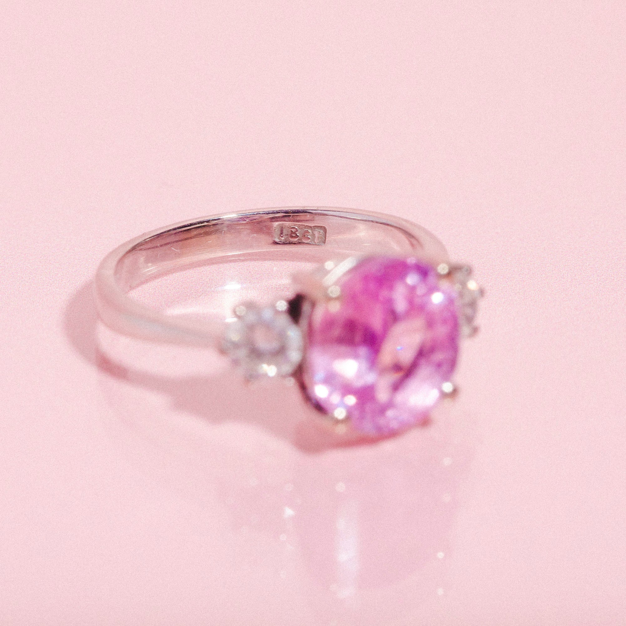 18ct white gold ring set with a pink sapphire and two diamonds