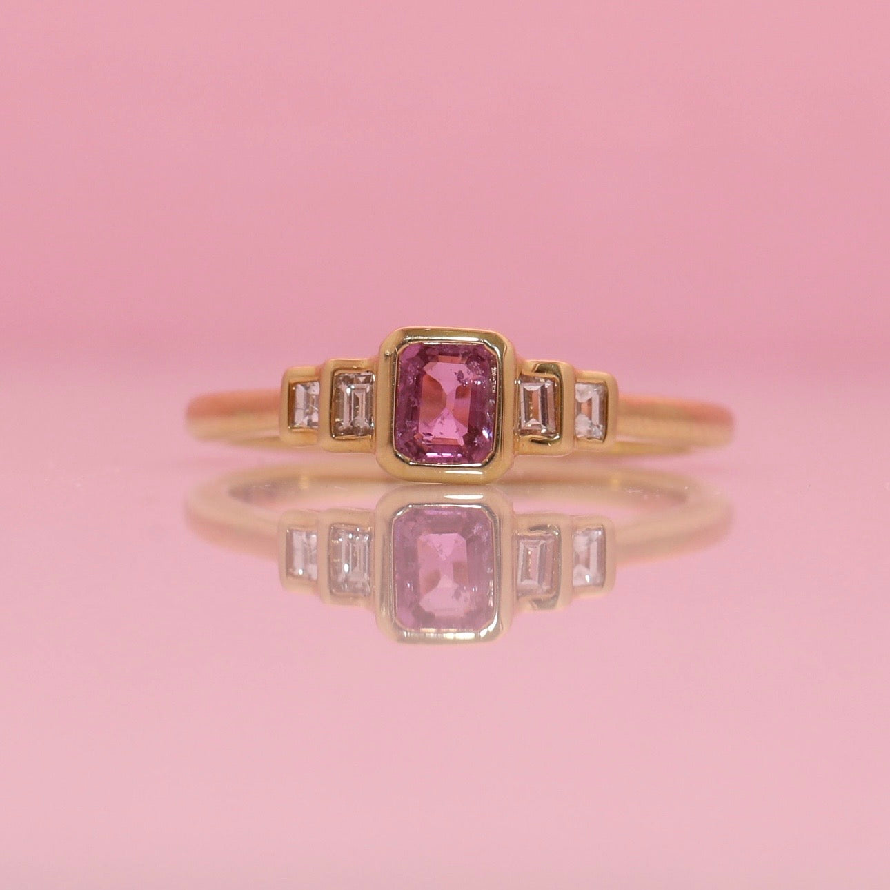 18ct gold 0.52ct emerald cut pink sapphire and baguette diamond three stone ring
