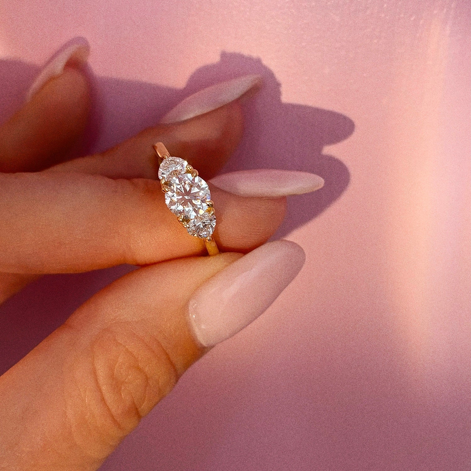 18ct gold trilogy ring with a 0.90ct round shaped diamond centre stone and two heart shaped diamonds