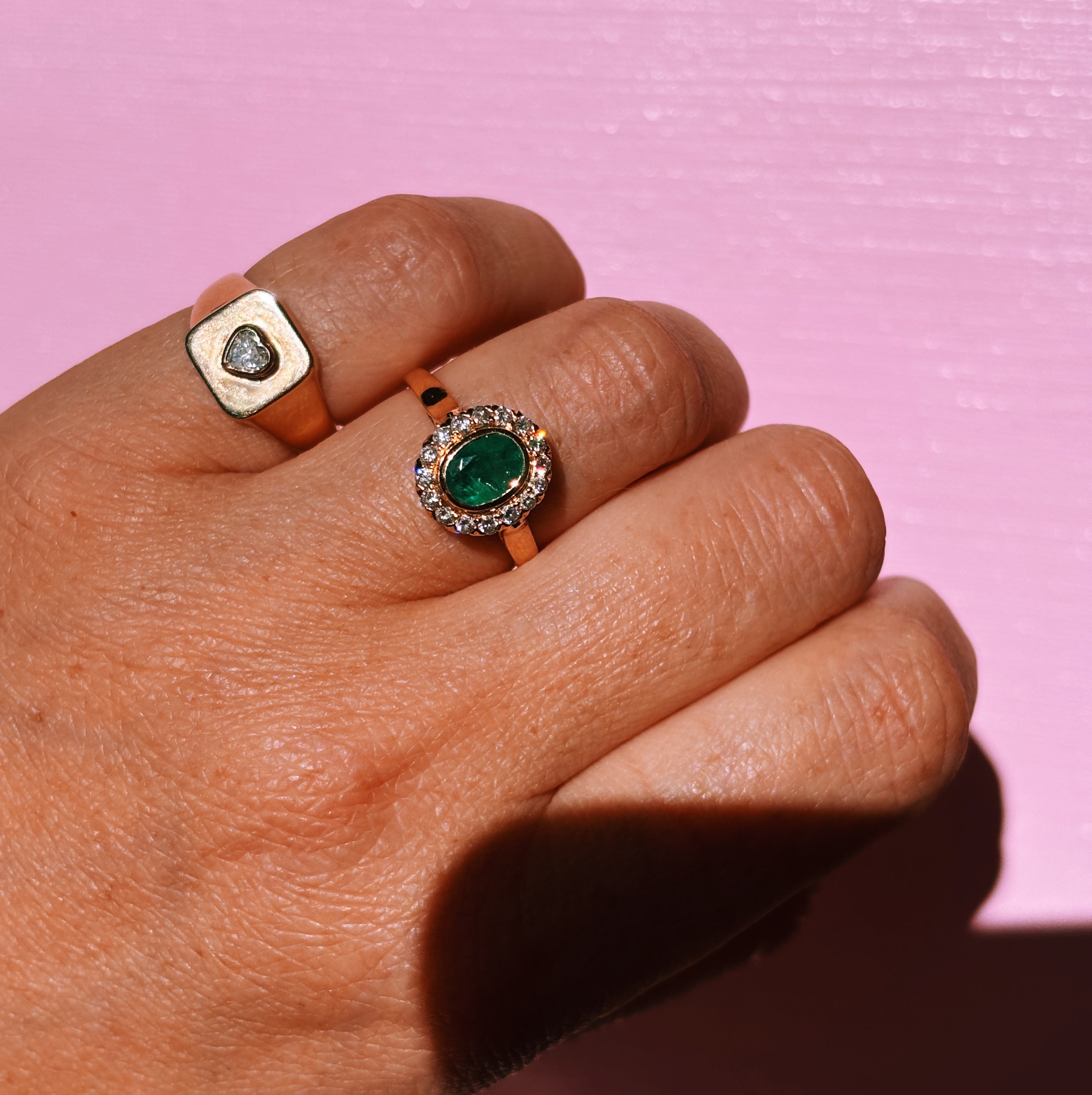 18ct gold bezel set, oval emerald and diamond cluster ring