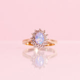18ct gold ring set with one opal and a diamond halo