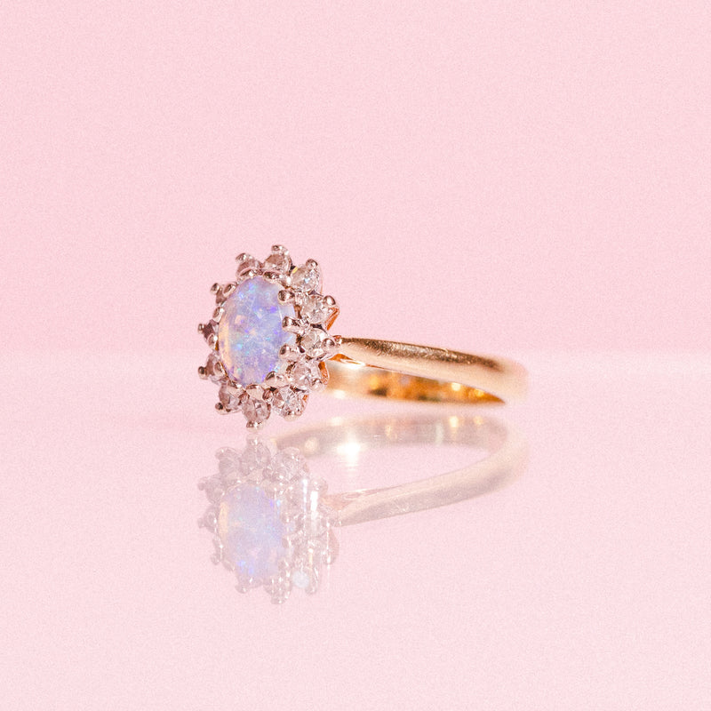 18ct gold ring set with one opal and a diamond halo