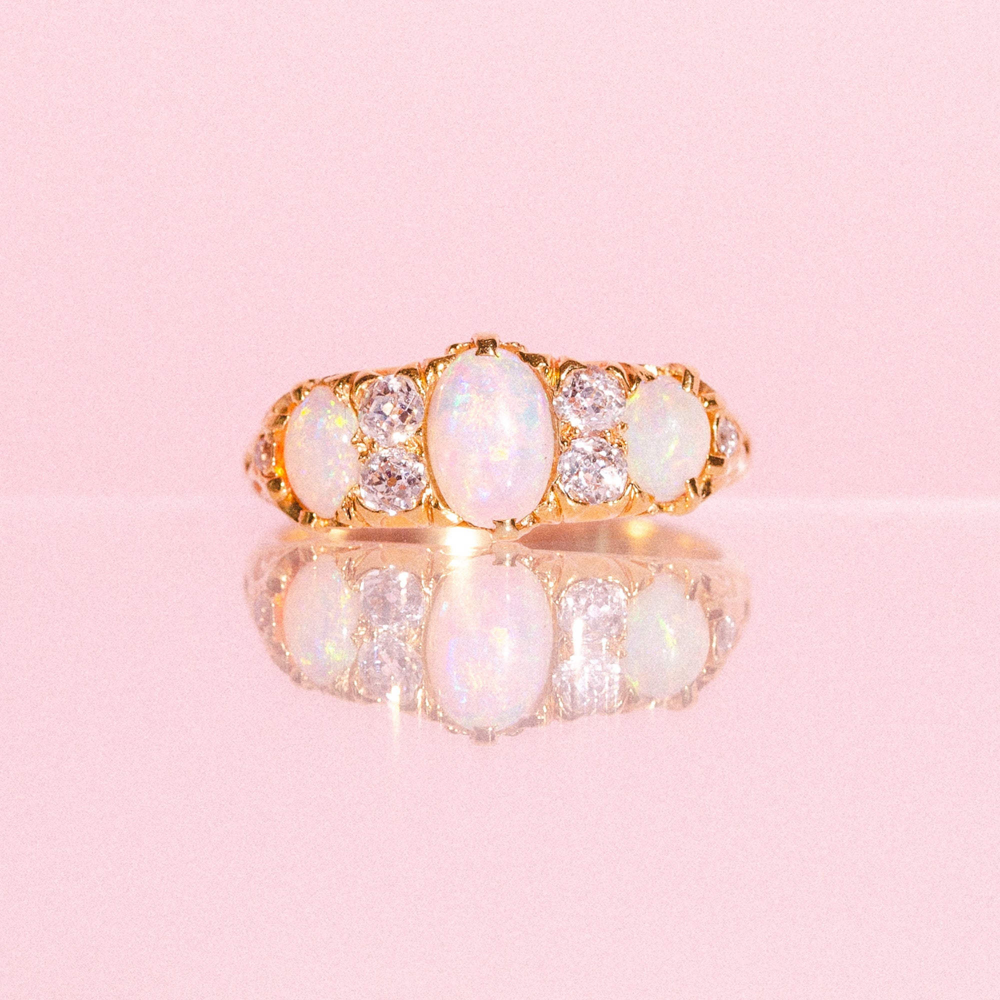 18ct gold ring set with three opals and four diamonds in a carved band