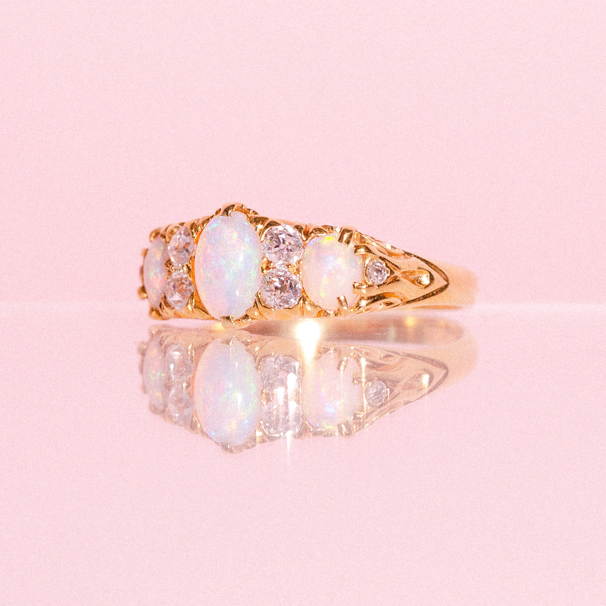 18ct gold ring set with three opals and four diamonds in a carved band