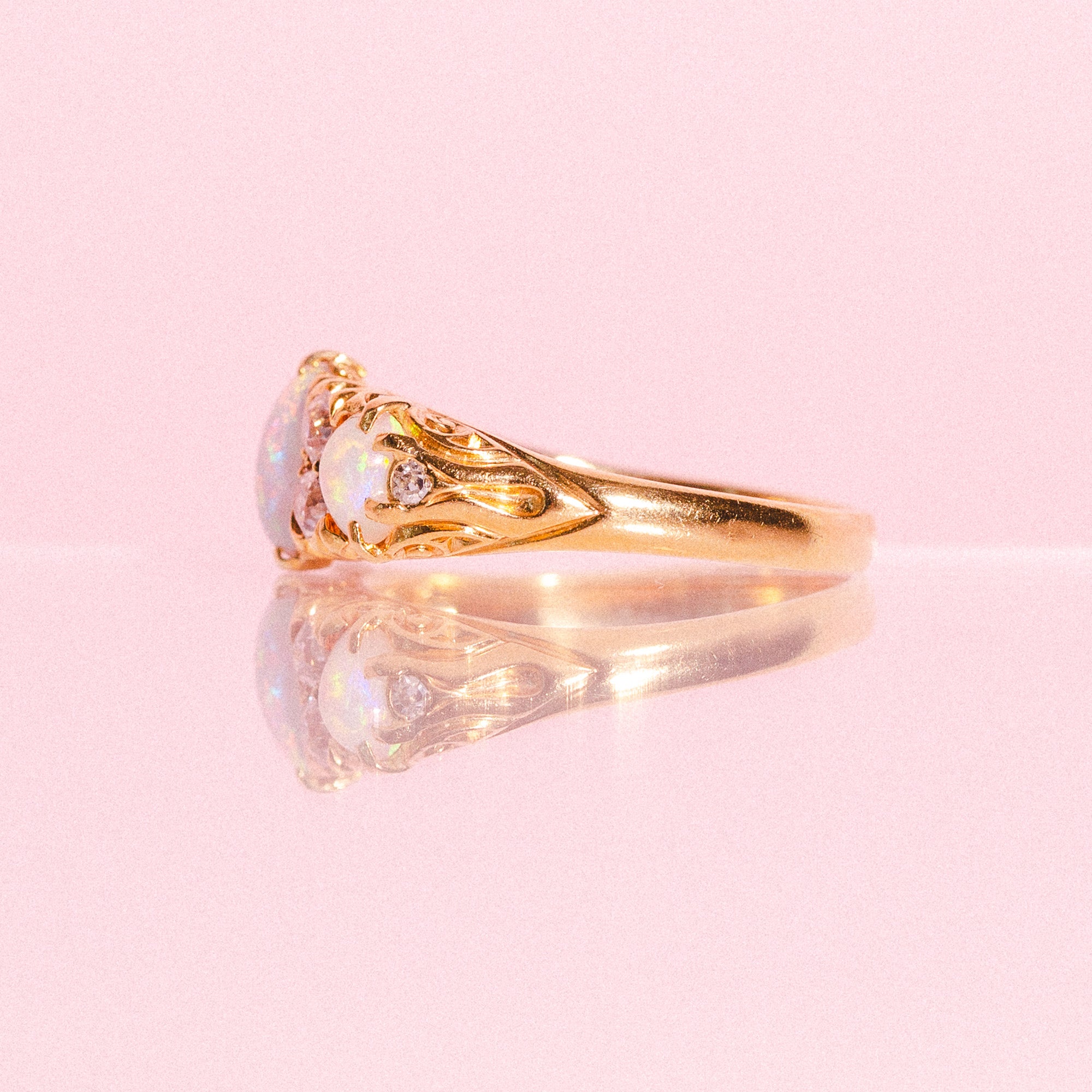 18ct gold ring set with three opals and four diamonds in a carved band