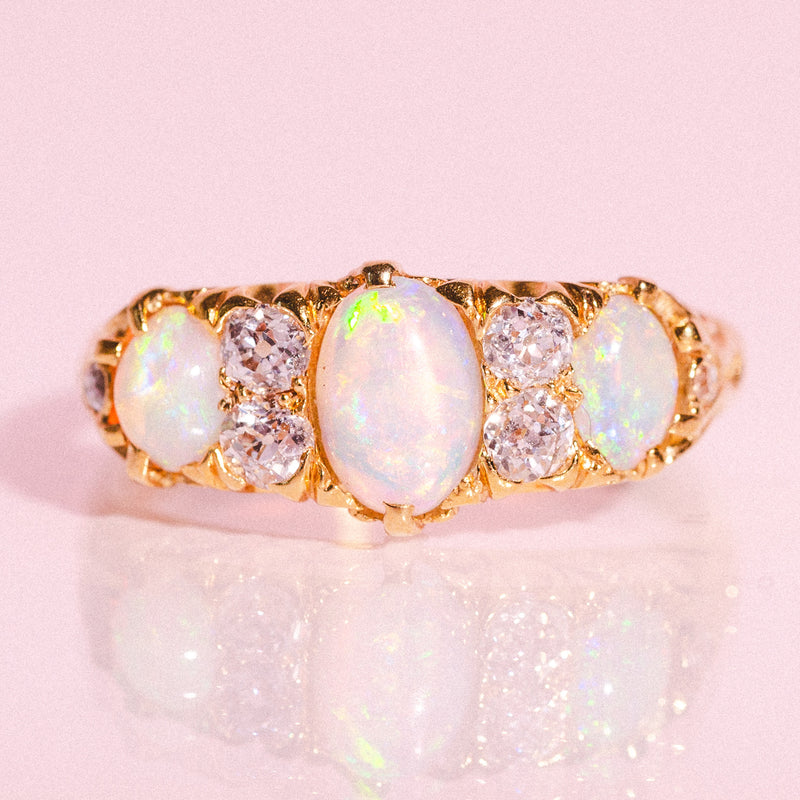 18ct gold ring set with three opals and four diamonds in a carved band