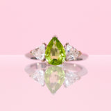 Platinum ring set with one pear shaped peridot and two diamonds