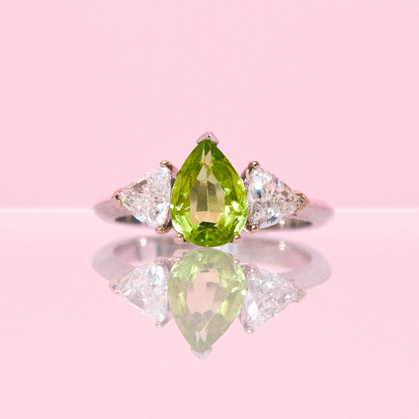 Platinum ring set with one pear shaped peridot and two diamonds