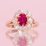 18ct gold ring set with a ruby and a diamond halo