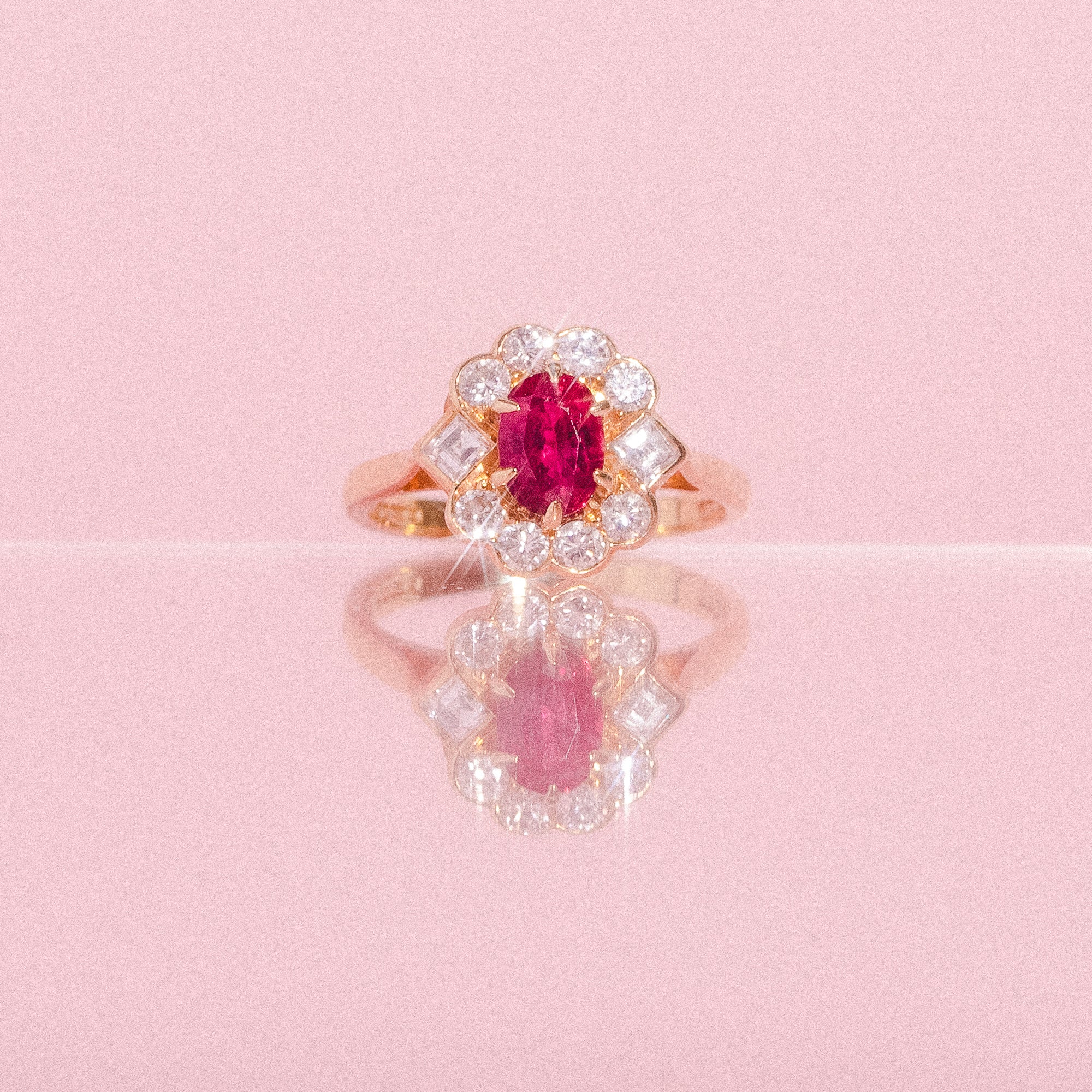 18ct gold ring set with a ruby and a diamond halo