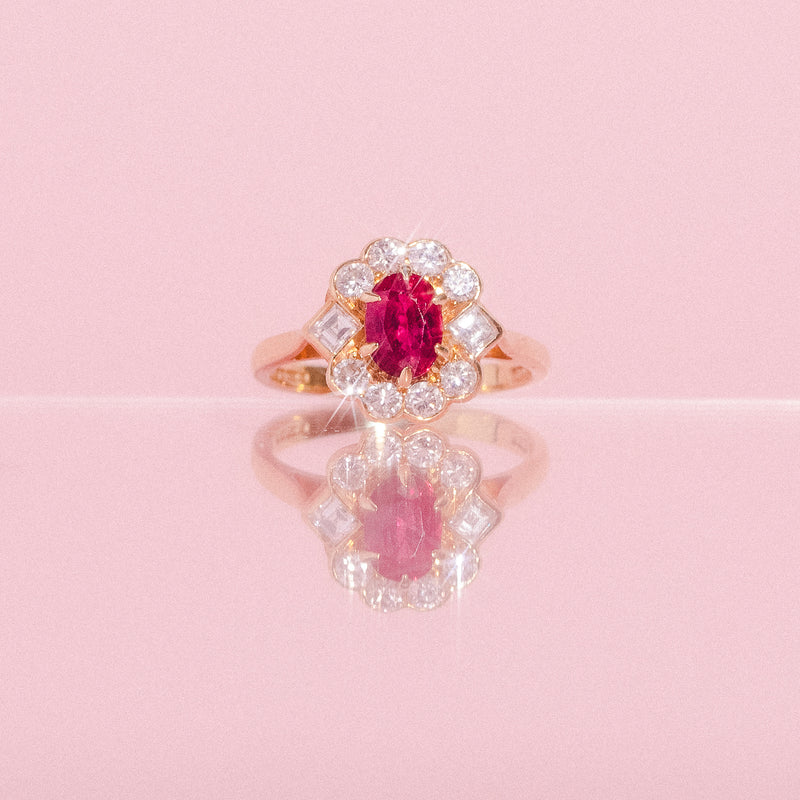 18ct gold ring set with a ruby and a diamond halo